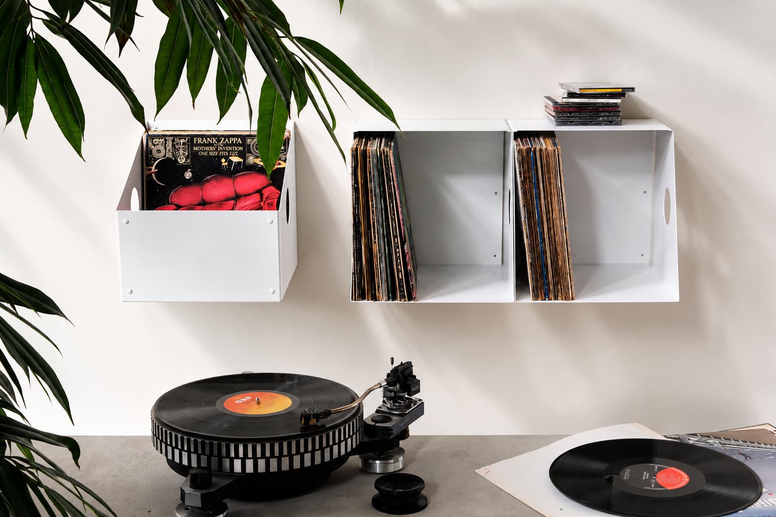 Bac à vinyle mural blanc TEEbooks avec disques 33 tours et platine, solution de rangement vinyle dans un intérieur lumineux.