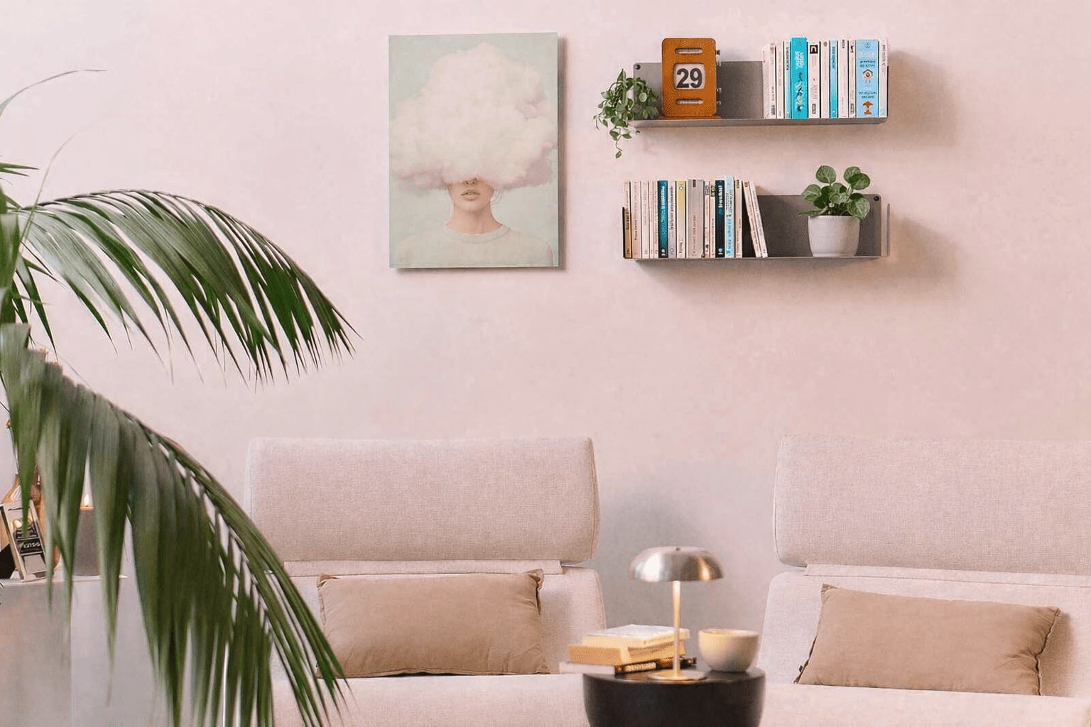 Bibliothèque murale moderne au-dessus d’un coin salon, combinant livres et plantes vertes pour apporter du rythme visuel et une touche de vie à l’espace.