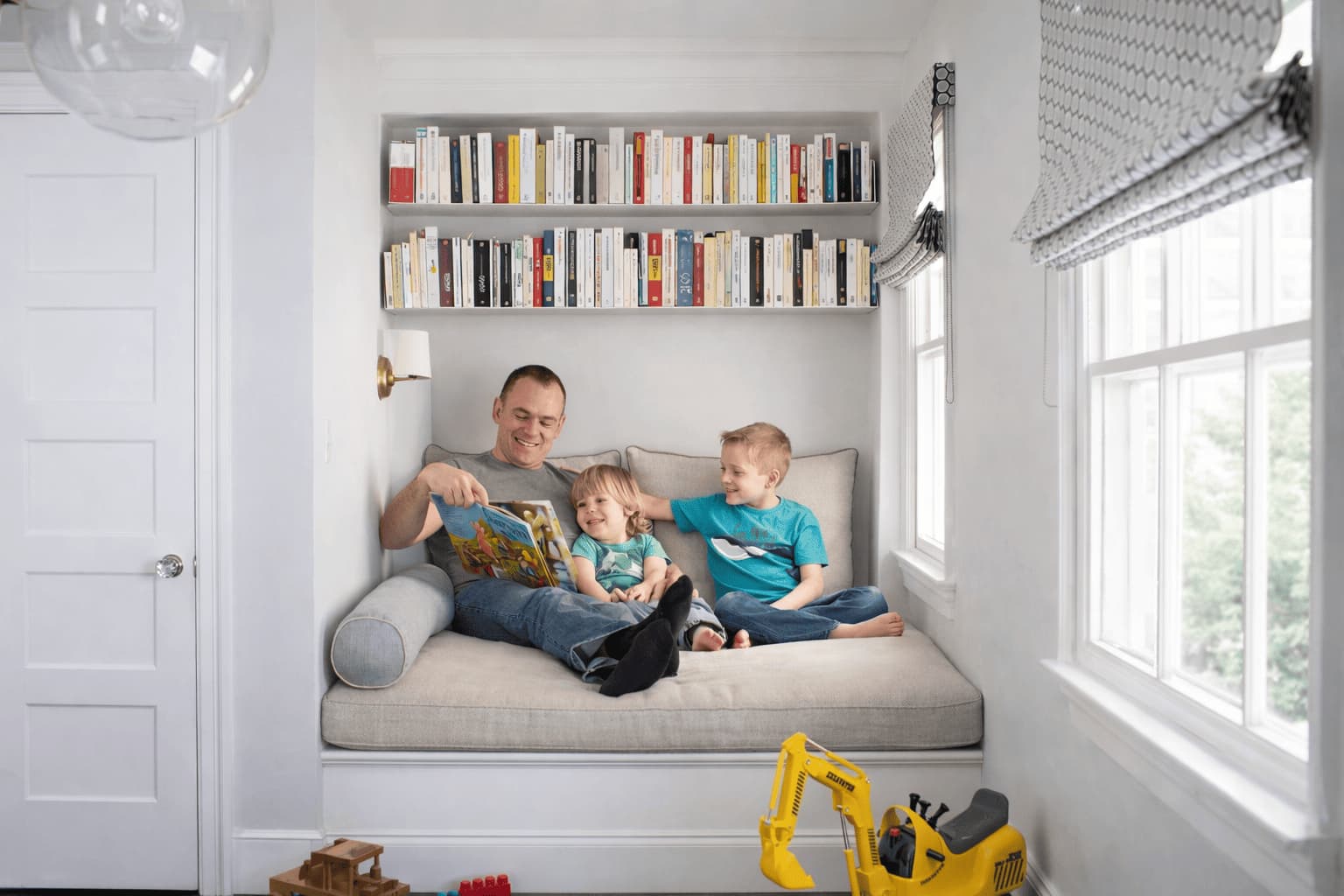 Coin lecture avec banquette sous la fenêtre et bibliothèque intégrée autour des livres