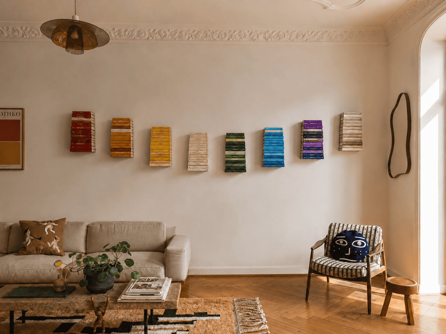 Étagères murales invisibles présentant des livres colorés pour habiller un mur vide dans un salon chaleureux