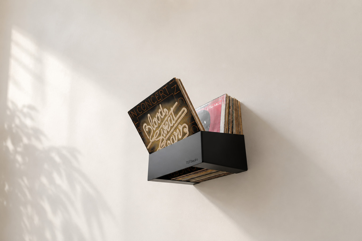 Disques vinyles 33 tours rangés dans un bac mural noir, une solution compacte pour ranger ses vinyles verticalement et garder les pochettes accessibles.