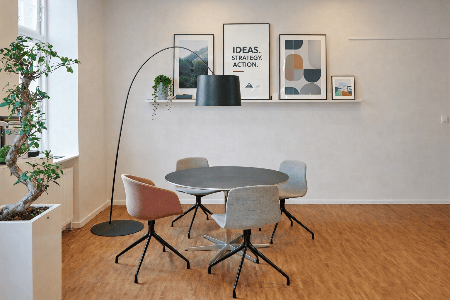 Décoration murale bureau avec étagère murale, cadres graphiques et éclairage design dans un espace de réunion professionnel