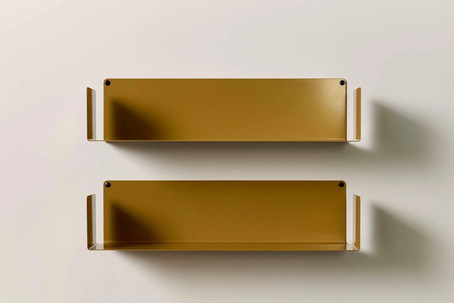 Lot de deux étagères avec équerre invisible en métal or antique, présentées vides sur un mur clair pour montrer leur design fin, leurs rebords latéraux et leur fixation murale discrète.