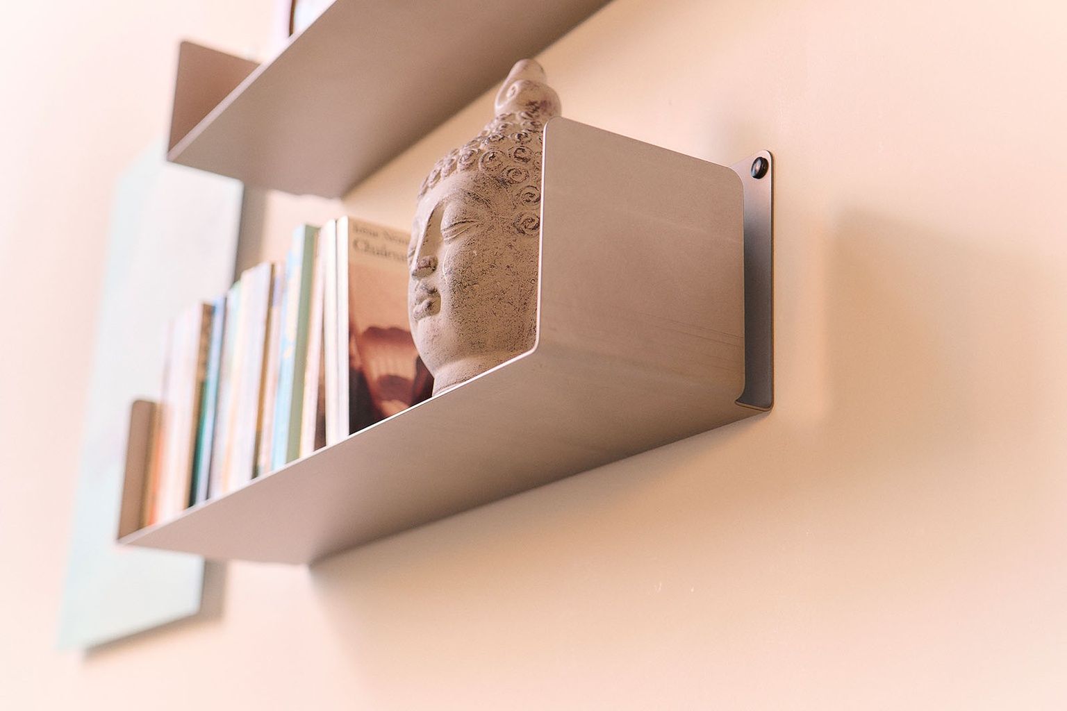 Étagère à fixation invisible en métal avec livres et objet décoratif en gros plan