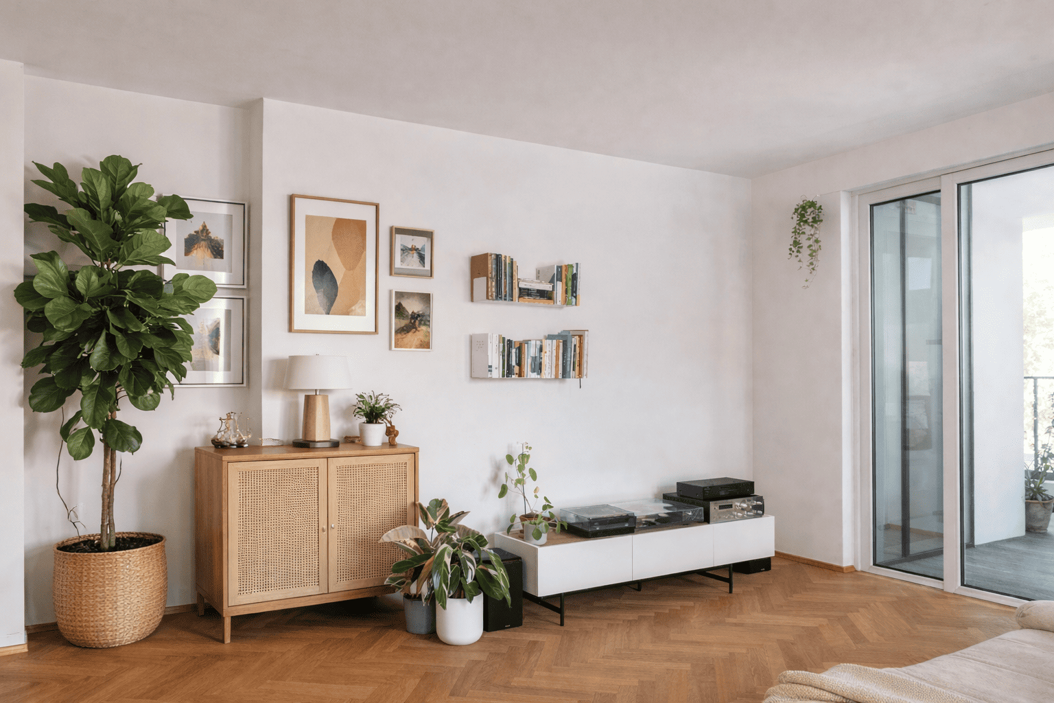 Étagères flottantes murales blanches dans un salon lumineux avec livres, plantes vertes et décoration naturelle