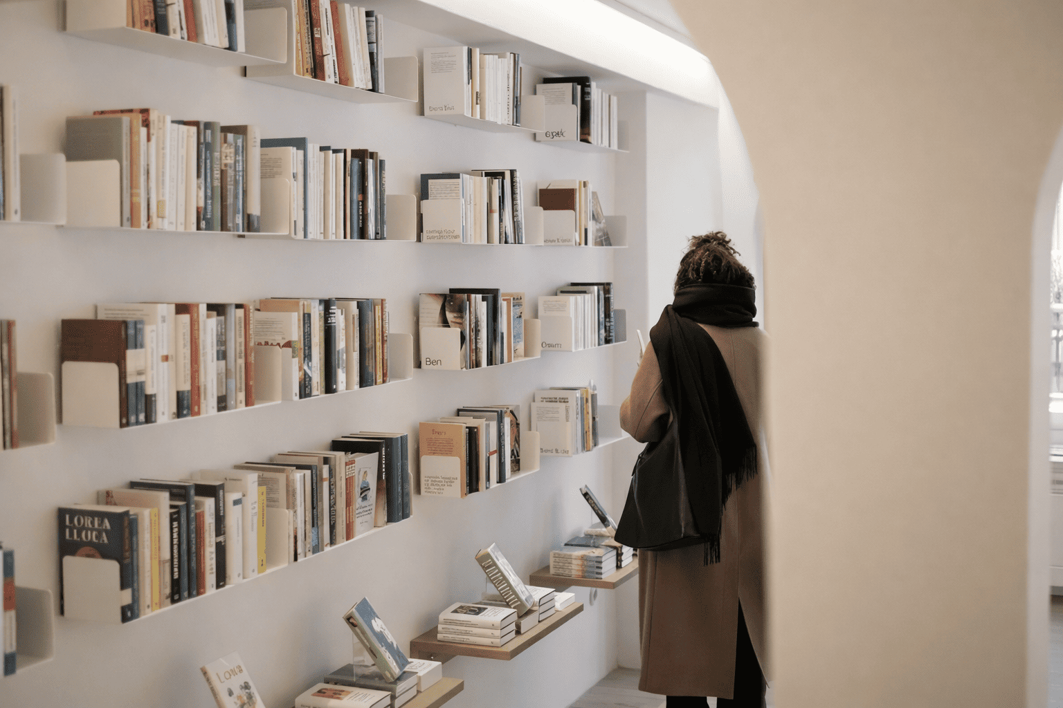 Rayonnage mural pour librairie avec étagères murales blanches exposant des livres à hauteur des yeux.