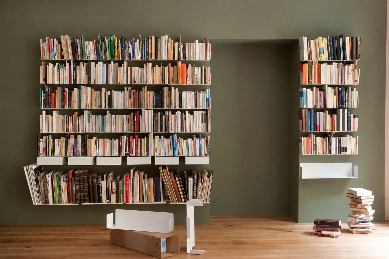 Idée de grande bibliothèque murale avec nombreuses étagères de livres couvrant presque tout le mur