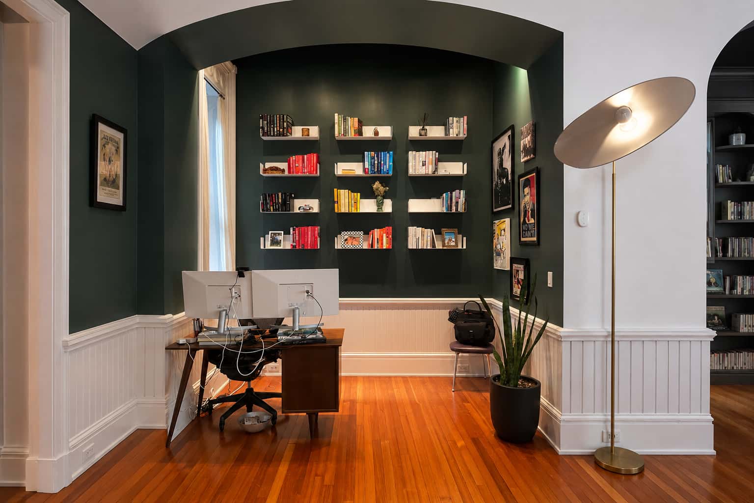 Idée de bibliothèque murale autour d’un bureau avec étagères de livres sur un mur vert