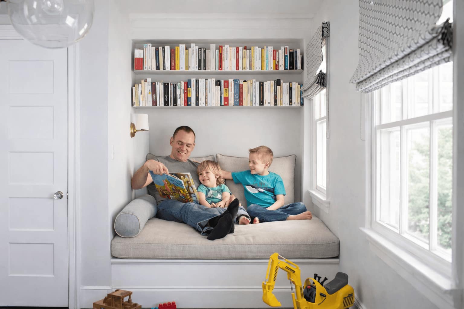 Bibliothèque murale pour enfants avec deux étagères de livres au-dessus d’une banquette de lecture