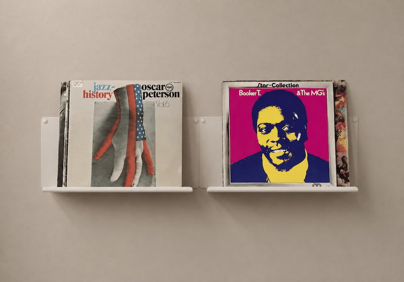 Deux présentoirs muraux blancs avec des pochettes de disques vinyles exposées face visible, pour mettre en valeur quelques albums sans stocker toute la collection.